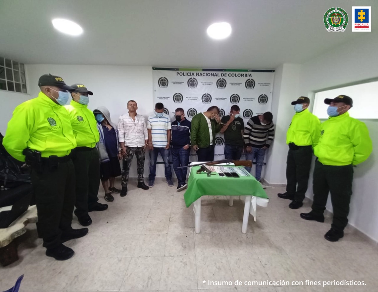 En la fotografía aparecen siete personas capturadas junto a cuatro uniformados de la Policía Nacional. En frente de los detenidos hay una mesa en la que se observa material incautado durante el operativo. En la parte posterior se ve un banner de la Policía Nacional