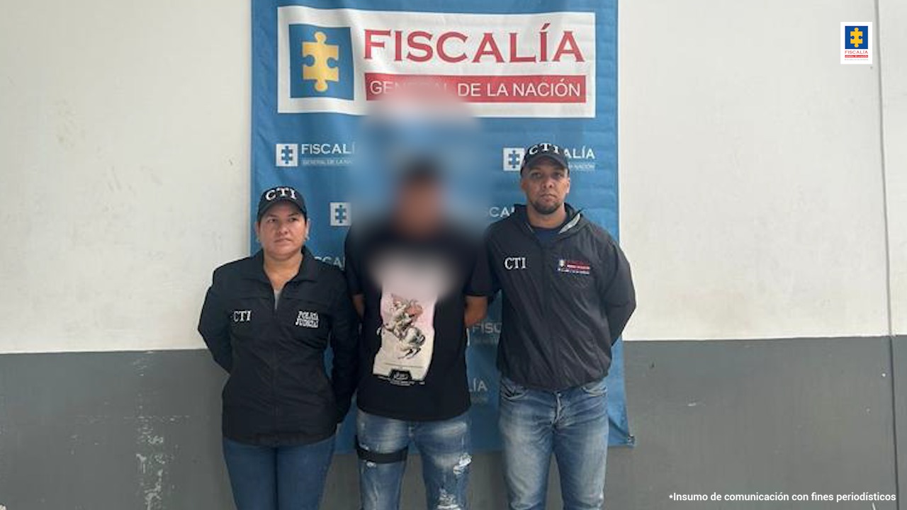 Dos funcionarios del CTI Atlántico custodian al presunto agresor sexual tras su captura.