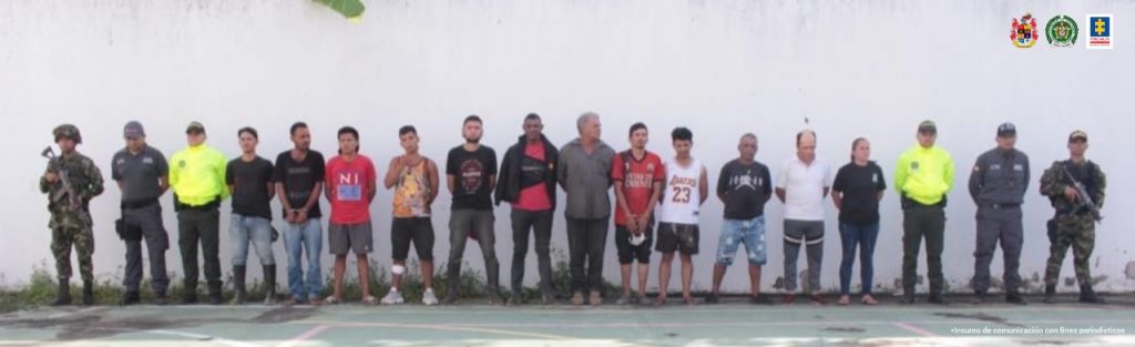 En la fotografía aparecen 11 hombres capturados y una mujer, acompañados de servidores del CTI y un uniformado de la Policía Nacional.