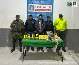 Una investigadora del Cuerpo Técnico de Investigación (CTI) custodia al procesado con el acompañamiento de uniformados de la Policía y del Ejército.
