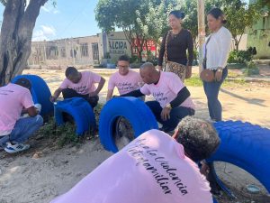 Se ve a los hombres con camisetas rosadas pintando un parque. 