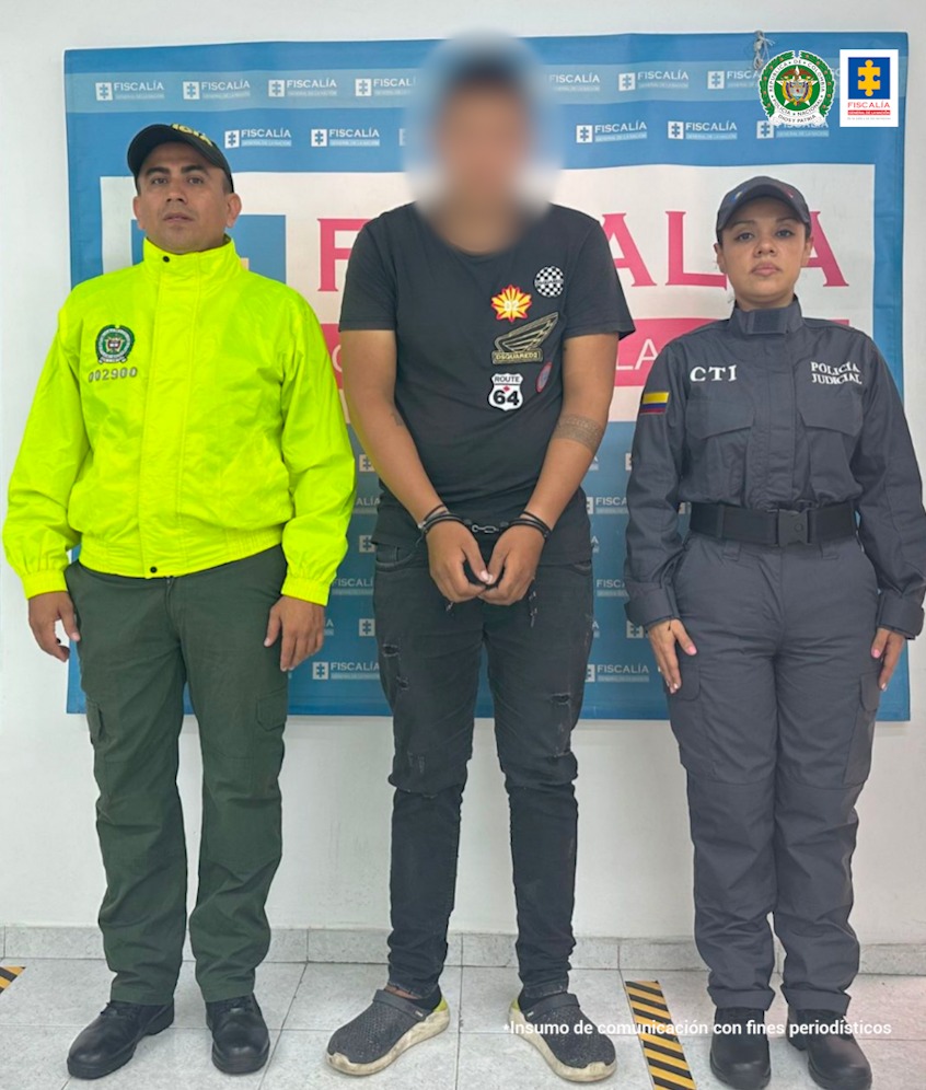 El capturado está esposado adelante, está custodiado por una sevidora del CTI de la Fiscalía y un uniformado de la Policía Nacional.