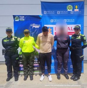 En la imagen se ve un hombre detenido mientras un investigador del CTI le lee sus derechos en calidad de capturado. Lo acompaña otro investigador y una integrante de la Policía Nacional.