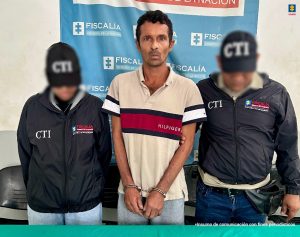 En la imagen un hombre delgado, de piel trigueña, esposado y acompañado de dos hombres del CTI.