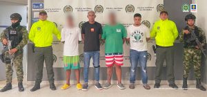 Los dos presuntamente implicados en un homicidio son custodiados por dos uniformados de la Policía Nacional.