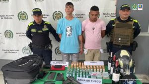 Dos uniformados de la Policía Nacional custodian a los procesados tras su captura mediante orden judicial.