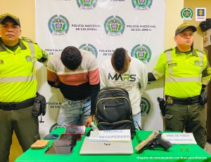 Dos uniformados de la Policía Nacional custodian a los procesados tras su captura mediante orden judicial.