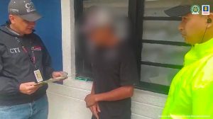 En la primera foto se ve al capturado al centro, en un extremo un funcionario del CTI y al otro uno de Policía Nacional, atrás el pendón de la Fiscalía General de la Nación.