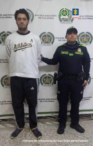 En la imagen se ve a un hombre capturado en compañía de un uniformado de la Policía. 