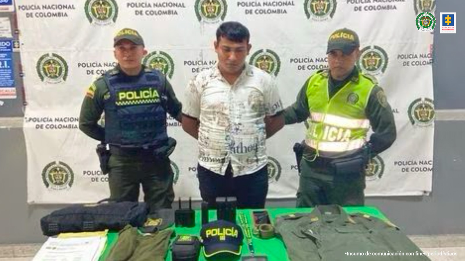 Dos uniformados de la Policía Nacional custodian al capturado quien al parecer se hacía pasar por un oficial de esa institución.