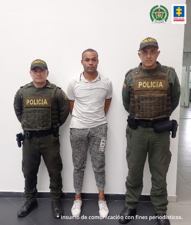 al centro de la fotografía se observa un hombre capturado y a cada uno de sus costados un funcionario de la Policía Nacional