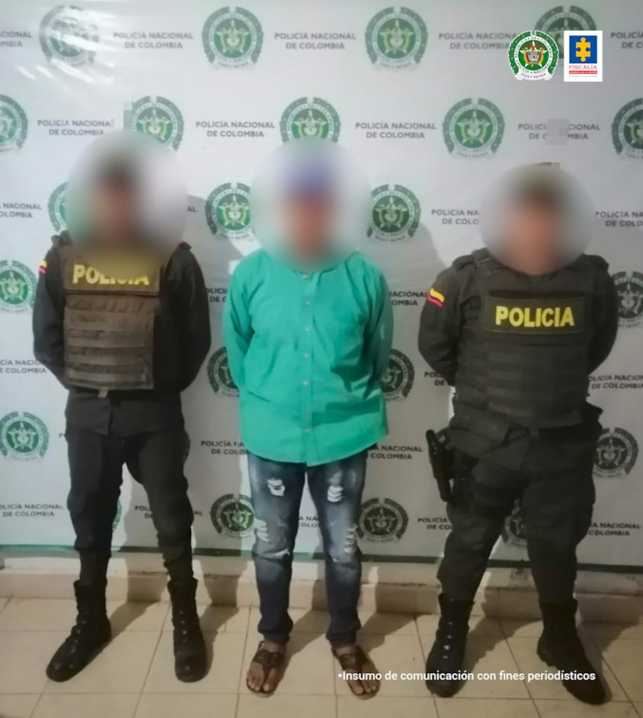 En la imagen hay una persona detenida entre dos uniformados de la Policía.