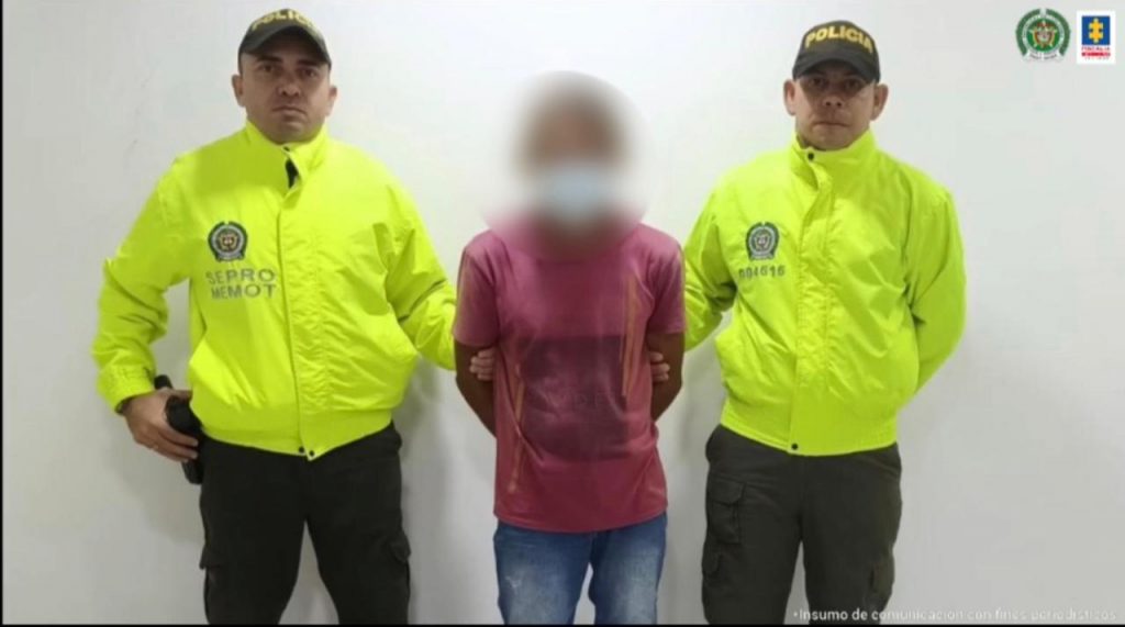 En la imagen se ve una persona detenida entre dos uniformados de la Policía.