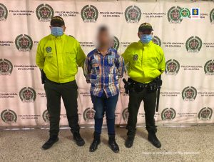 En la imagen aparece el procesado con el rostro distorsionado y en medio de dos patrulleros de la policía.