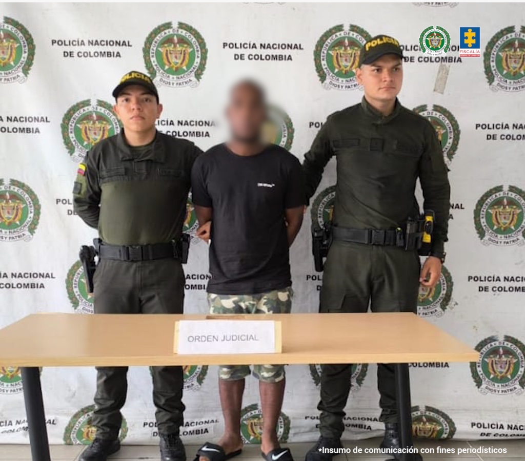 En la fotografía aparece el capturado junto a dos agentes de la Policía Nacional. En la parte superior se observa un banner de la Policía Nacional