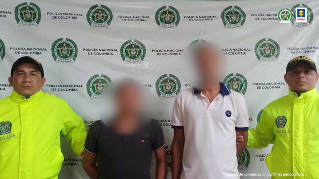 En la imagen aparecen dos personas detenidas entre dos uniformados de la Policía Nacional.