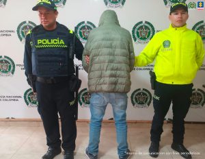 En la imagen aparece el detenido esposado de espaldas junto a uniformados de la Policía Nacional 