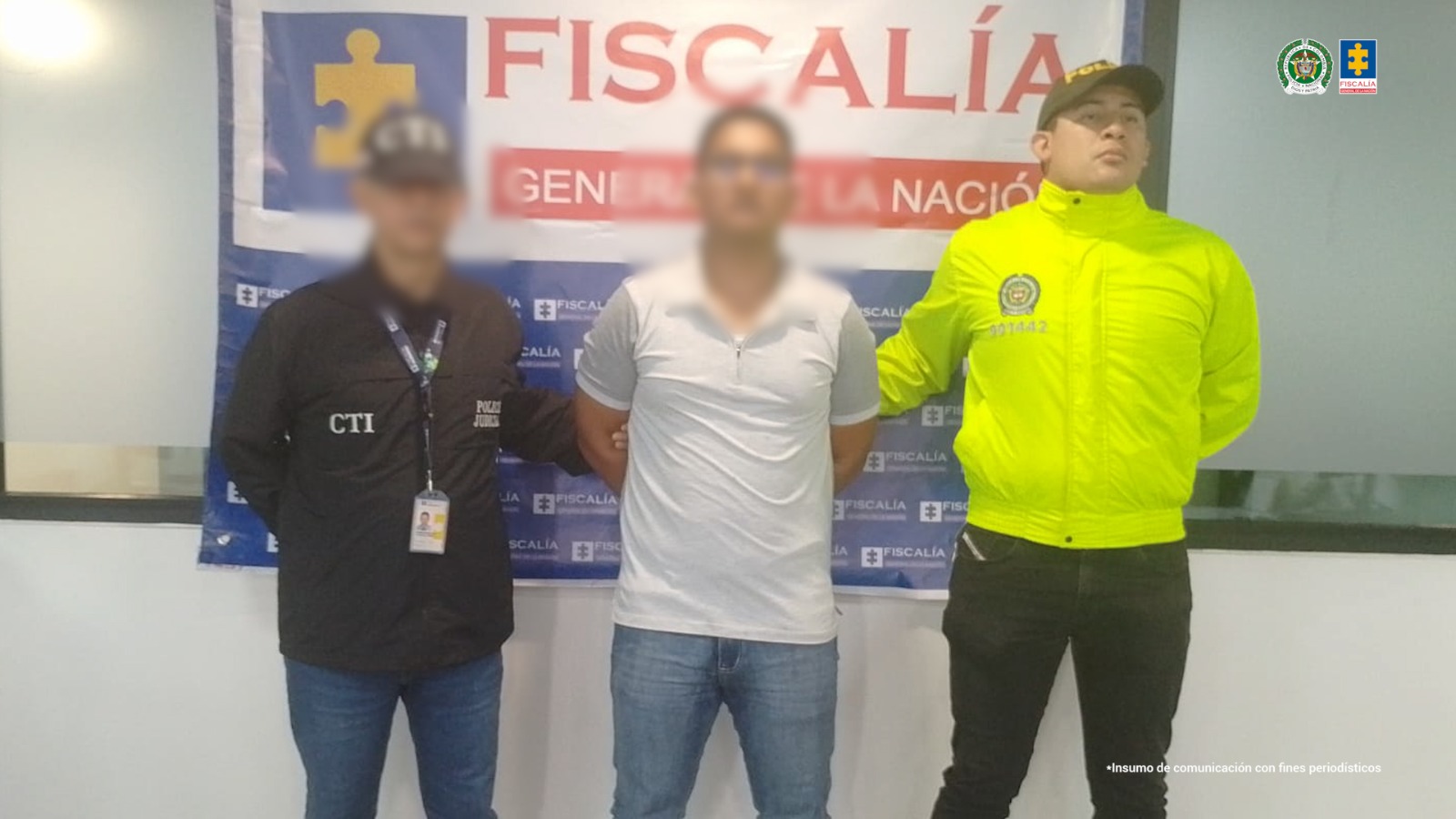 Se visualiza al capturado junto a un investigador del CTI y un uniformado de la Policía Nacional. Detrás de ellos el banner que identifica a la Fiscalía General de la Nación.
