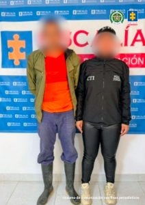 En la fotografía aparece el capturado junto a una servidora del CTI. En la parte posterior está un banner de la Fiscalía General.