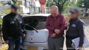 En la fotografía aparece el capturado junto a dos servidores del CTI