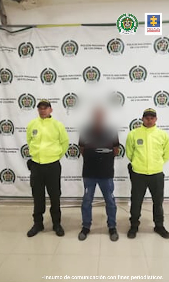 En la imagen se ve un adulto mayor con la cara tapada, entre dos uniformados de la Policía.