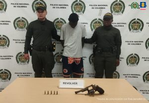 En la fotografía aparecen los capturados junto a dos agentes de la Policía Nacional. En la parte superior está un banner de la Policía Nacional