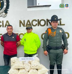 En la fotografía aparece un capturado junto a personal de Policía Nacional. En la parte posterior de la imagen se ven banners de Policía Nacional y la Fiscalía General de la Nación.