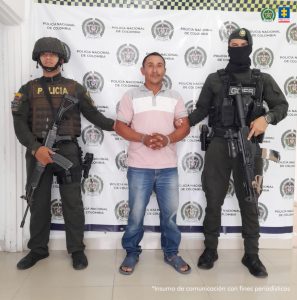 En la foto está el procesado con un servidor de la Sijín y uno del Goez de la Policía Nacional