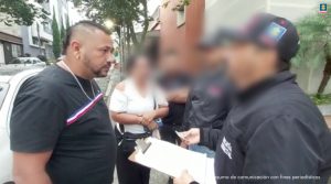 Se observa al capturado al frente de la parte frontal de un vehículo con el capó abierto, al frente, dos funcionarios del CTIPIE DE FOTO: Sergio Andrés Ayala León participó en los crímenes cometidos contra un hombre en Dosquebradas (Risaralda)
