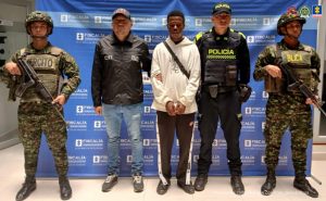 En la fotografía aparece el capturado junto a un servidor del CTI, un agente de la Policía Nacional y dos soldados del Ejército Nacional. En la parte superior está un banner de la Fiscalía General de la Nación