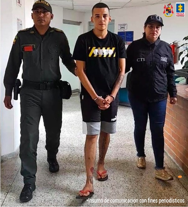 El capturado aparece caminando, con dos personas del CTI de la Fiscalía sujetándolo de los brazos