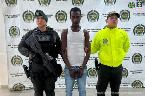En la fotografía aparece el capturado junto a dos agentes de la Policía Nacional. En la parte superior está un banner dela Policía nacional