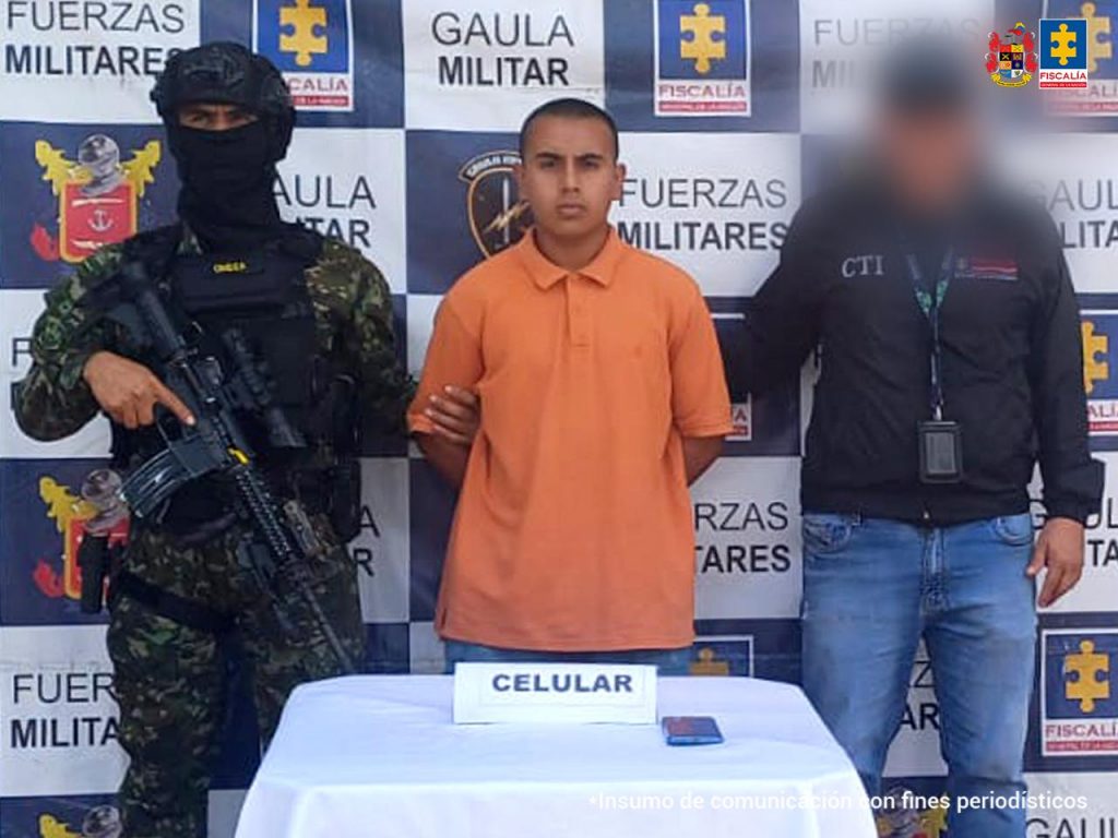 El capturado se encuentra de frente y custodiado por un servidor del Cuerpo Técnico de Investigación CTI y un uniformado del Ejército Nacional.