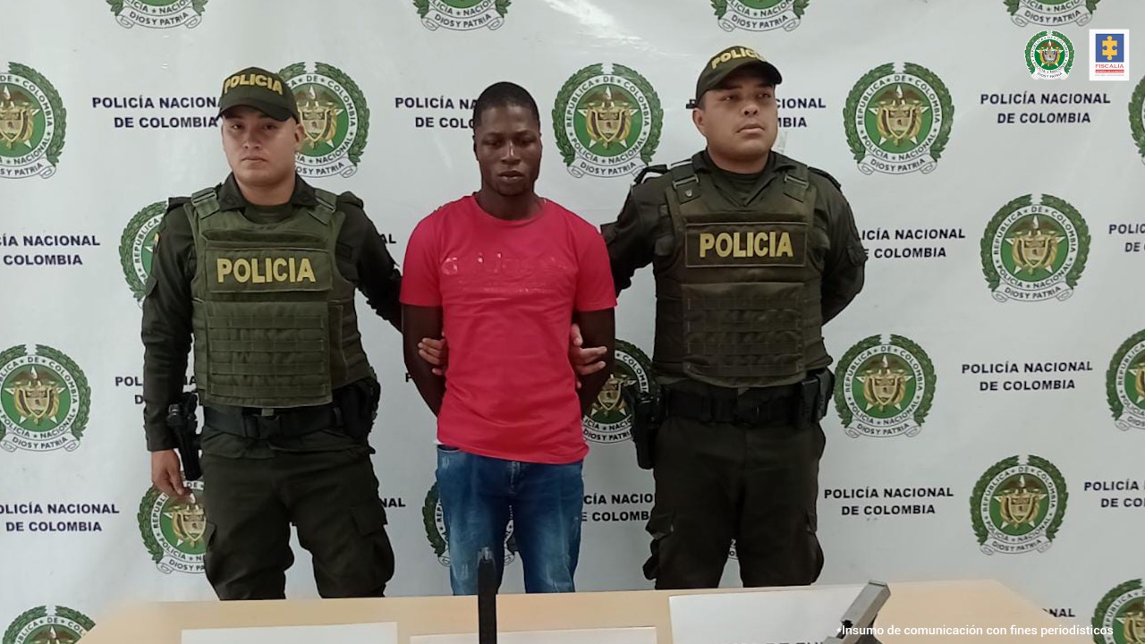 El captruado aparece esposado, en medio de dos personas de la Policía.