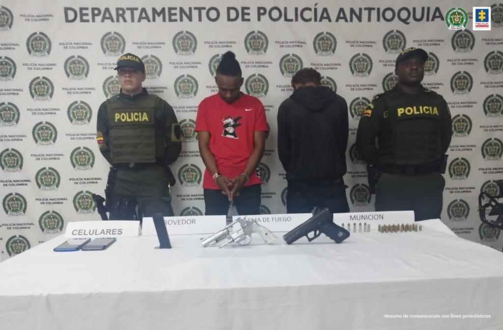 En la foto está alias Dover con camiseta roja, un menor de edad de espaldas aprehendido y dos servidores de la Policía Nacional a los lados.