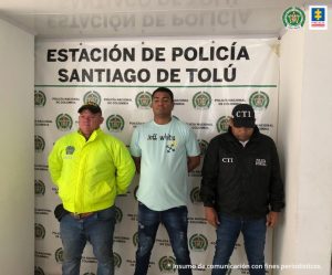 En la imagen se ve una persona detenida entre dos uniformados de la Policía Nacional.