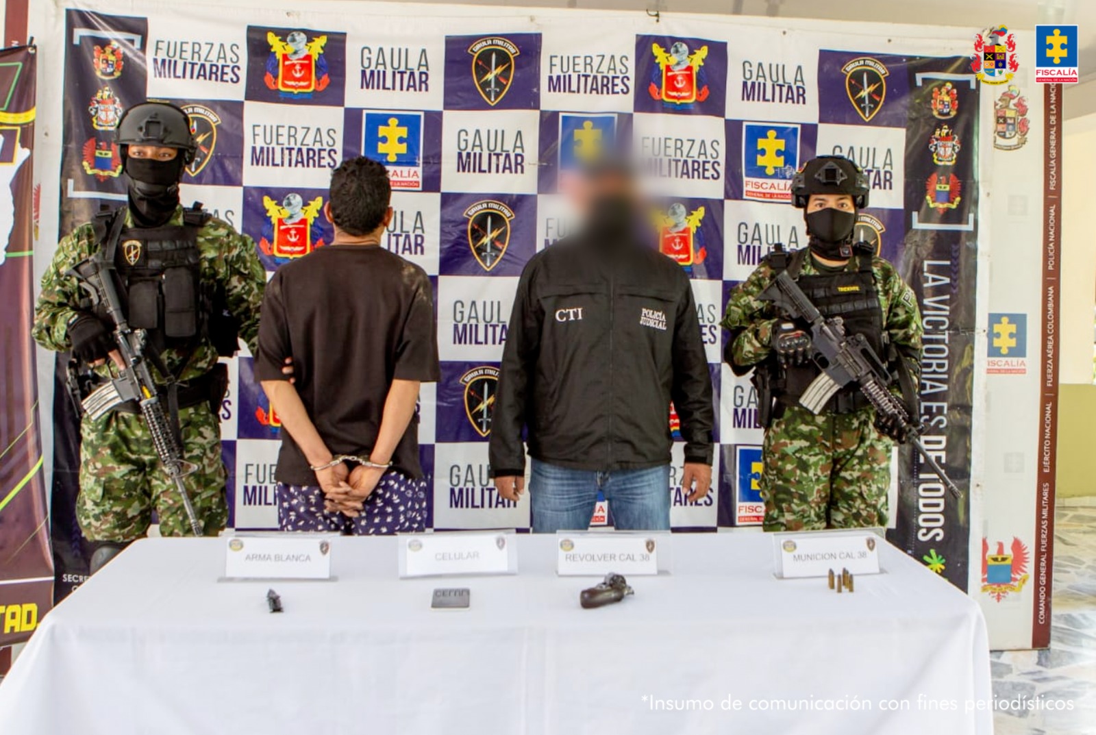El imputado se encuentra en custodia por un servidor del Cuerpo Técnico de Investigación CTI y dos uniformados del Gaula del Ejército. Detrás hay un backing del Ejército y se observa el material incautado.