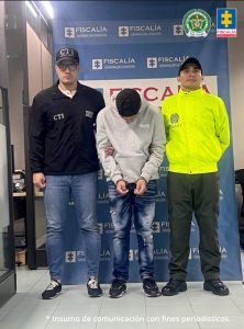  En la imagen aparece el investigado en medio de un servidor del CTI y un patrullero de la policía.