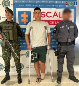 En la fotografía aparece el capturado junto a un servidor del CTI y un funcionario del CTI. En la parte superior está un banner de la Fiscalía General.