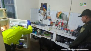 En la foto se observa dos uniformados de la Policía Nacional dentro de uno de los inmuebles. Se observa la cocina y como inspeccionan dentro de una nevera en busca del estupefaciente.