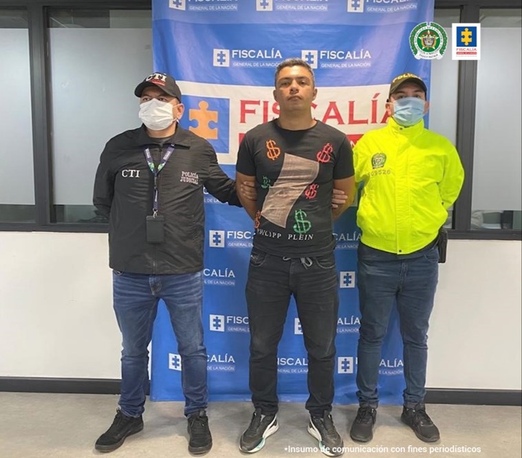 En la fotografía aparece el capturado junto a un investigador del CTI y un integrante de la SIJIN. En la parte posterior se observa el banner que identifica a la Fiscalía General de la Nación.
