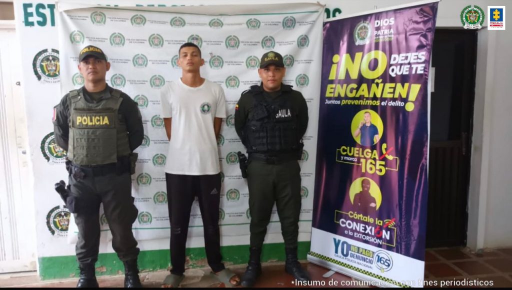 En la imagen se ve una persona detenida entre dos uniformados de la Policía.