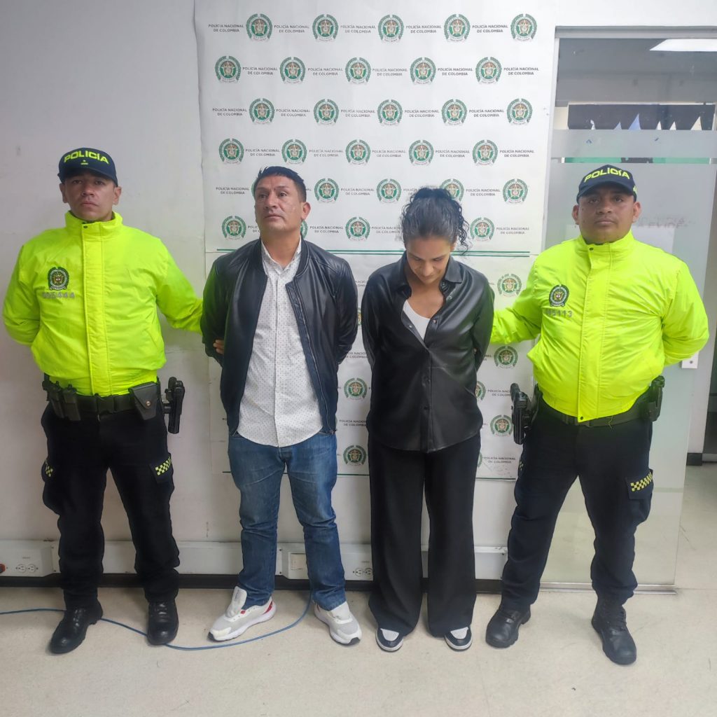 En la imagen están la mujer y el hombre capturados en medio de dos servidores de la Policía Nacional