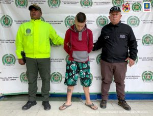 En la imagen se ve un joven detenido bajo custodia de un investigador del CTI y otro de la Policía Nacional.