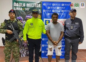 En la imagen se ve una persona detenida entre uniformados de la Policía, el Ejército y la Fiscalía.