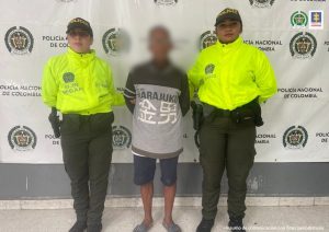 El abuelo es custodiado por dos uniformados de la Policía Nacional tras su captura en Barranquilla.