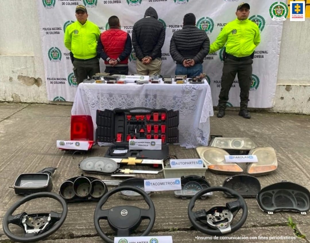 En la fotografía se observan a los 6 capturados junto a dos agentes de la Policía Nacional. En la parte posterior se observa una mesa con dinero, teléfonos celulares, un televisor, chaquetas, bolsos, cascos y una patineta.