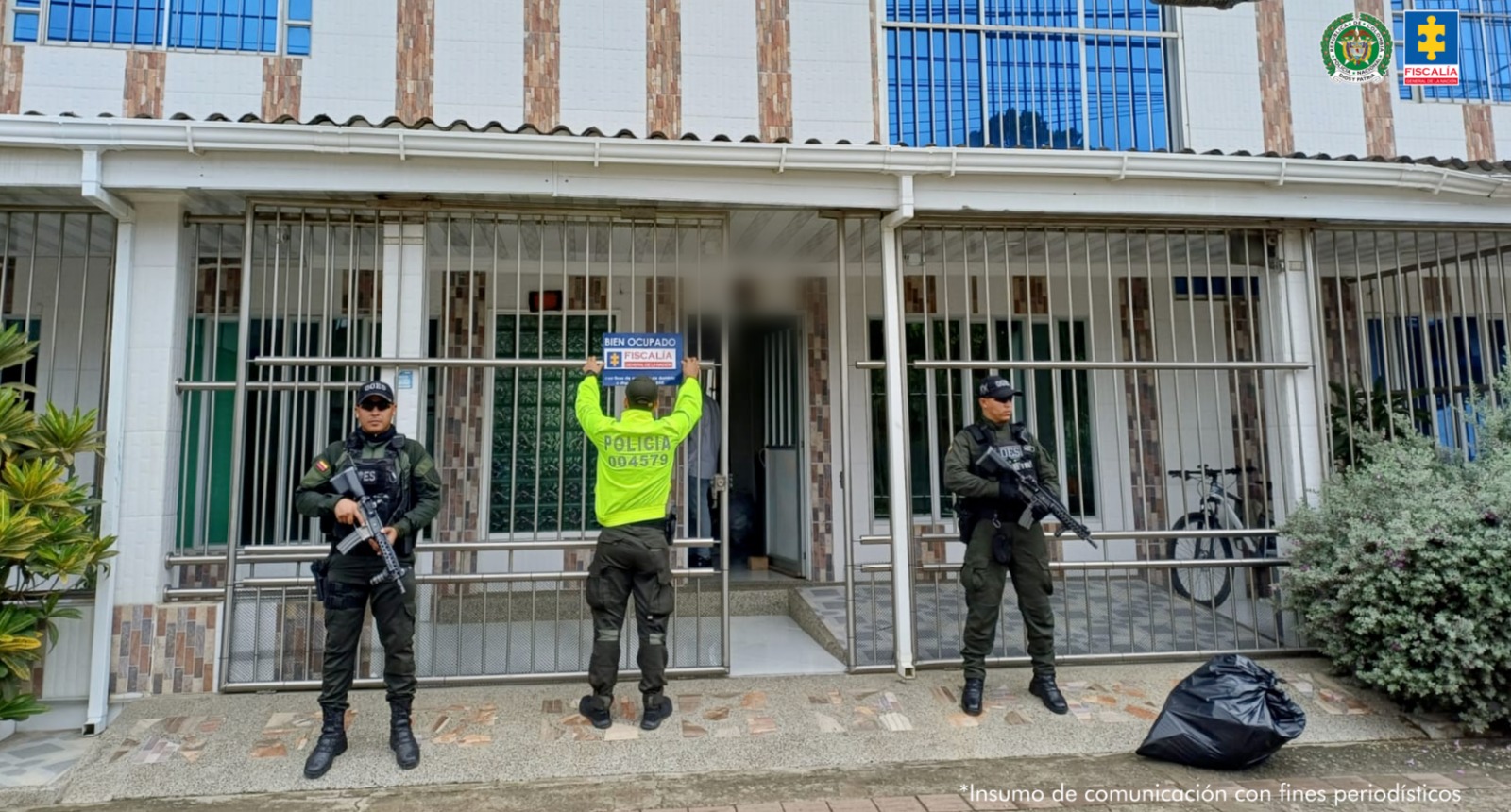 En la imagen puede verse un bien y frente a él servidores de la Policía y del CTI de la Fiscalía. 