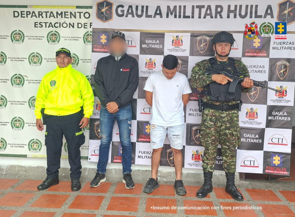 En la foto se observa al capturado custodiado por un servidor del Cuerpo Técnico de Investigación CTI y uniformados de la Policía y Ejército Nacional. También se observa un backing de la Policía y Ejército Nacional.