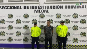En la fotografía se aprecia de pie y con los brazos atrás a Brayan Herney Lozano Calderón. Viste con camiseta negra, de manga corta, con estampado blanco y rayas blancas verticales en los costados; Pantalón negro. Usa lentes. A sus extremos hay uniformados de la Policía Nacional. Detrás de ellos hay un pendón institucional de la Policía.